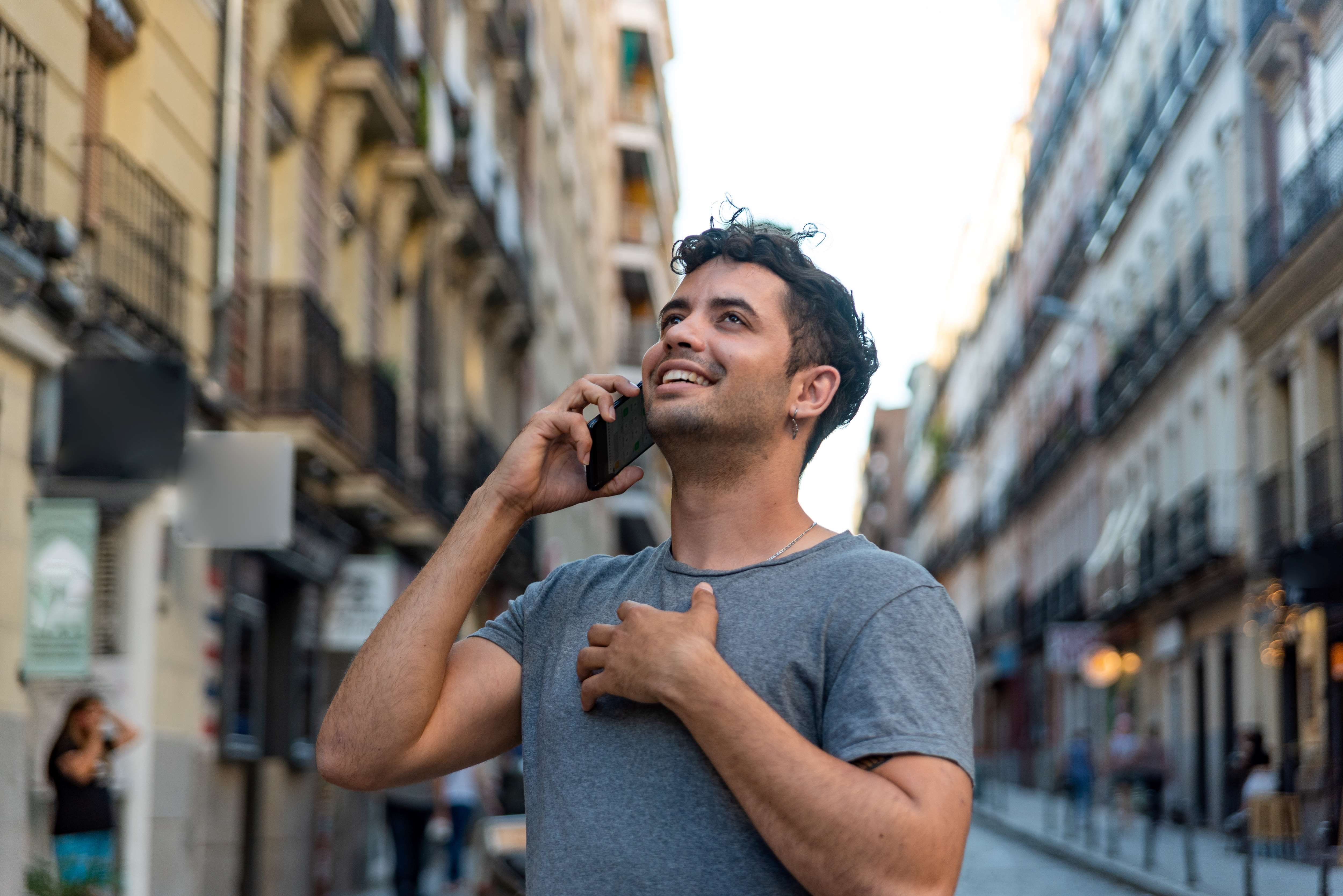 man on phone on street in city